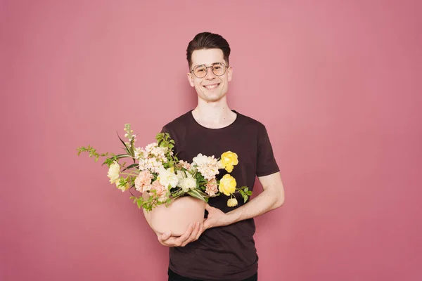 Szczęśliwy przystojny młody człowiek trzyma kilka kwiatów. — Zdjęcie stockowe