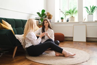 Anne ve kızı evdeki oturma odasında çay içiyorlar.