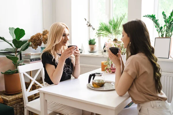 Madre con hija bebiendo té juntos en la cocina en la mesa — Foto de Stock