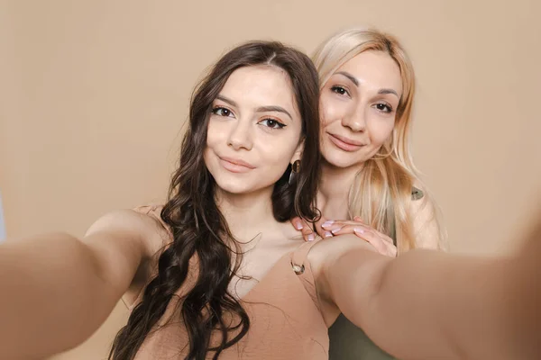 Mamma e figlia fare selfie su sfondo beige — Foto Stock