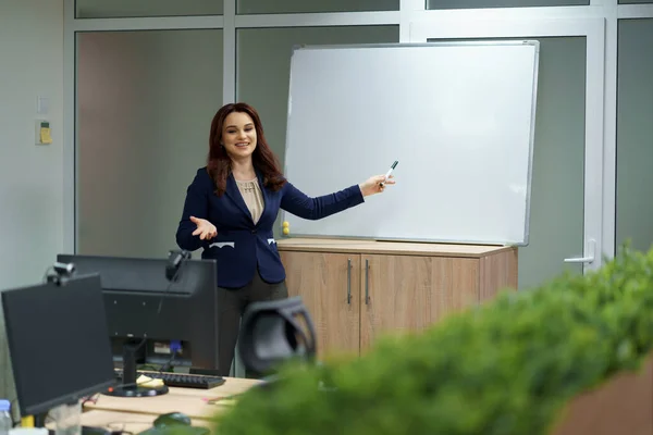 Mujer explicando en pizarra en la oficina, e-learning — Foto de Stock