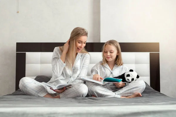 Όμορφη Μητέρα Την Κόρη Πιτζάμες Κάθεται Στο Κρεβάτι Διαβάζοντας Ένα — Φωτογραφία Αρχείου
