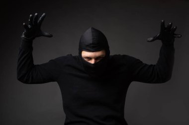 Eller havada, siyah maskeli bir hırsız.