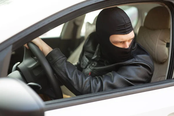 gangster in a black mask steals someone else\'s car