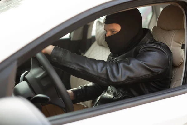 gangster in a black mask steals someone else\'s car