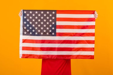 Amerikan bayrağı kadının ellerinde sarı arka planda