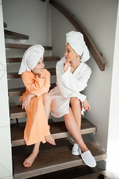家の階段に座っているバスローブの娘を持つ美しいお母さん — ストック写真