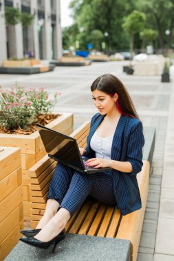 Dizüstü bilgisayarı olan takım elbiseli güzel bir kadın.