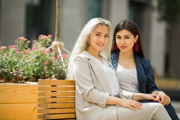 two beautiful young women in suits