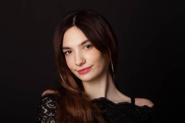 Siyah arka planda makyajlı güzel bir genç kadın. 