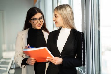 Ofiste takım elbiseli iki güzel genç bayan. 