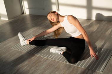 İnce vücutlu güzel bir kadın koridorda yoga yapıyor. 