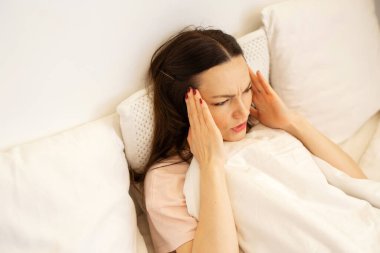 Güzel genç bir kadın soğuk nevresimle yorganın altında yatıyor. 