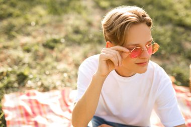güneş gözlüğü takan yakışıklı genç