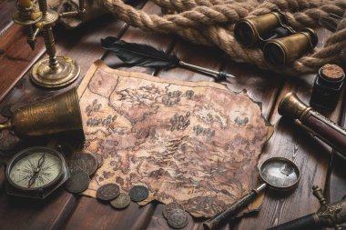 Eski ahşap masa arka planında korsan hazine haritası.