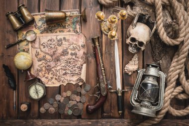 Kahverengi ahşap masa konseptindeki hazine haritası ve diğer aksesuarlar..