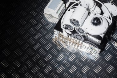 Metal masa arka planında kamera ve video kaydedici.