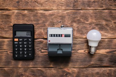 Hesap makinesi, ampul ve elektrik sayacı. Elektrik maliyeti kavramının hesaplanması.