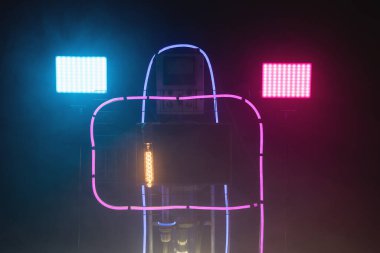 Fütürist cihaz kavramı. Dumanlı arkaplanda öncü ve neon lambalarda bilgisayar görüntüsü.