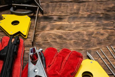 Kaynak makinesi, elektrotlar, eldivenler, manyetik köşeler ve çalışma tezgahındaki diğer ekipmanlar.