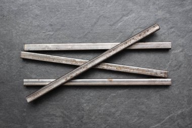 Siyah düz arkaplandaki siyah metal profil tüpleri.