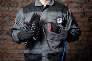 Lastik tamircisi, araba lastiği şişirme tabancası ve araba sopasıyla yakınlaş..