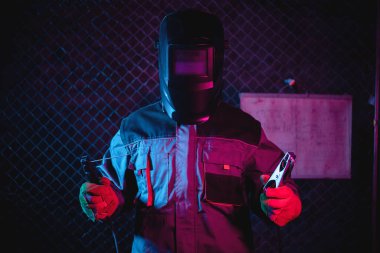 Kaynak kaskındaki neon ışıklardaki kaynakçı..