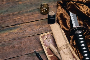 Katana kılıcı ve kadim kağıt parşömen kahverengi tahta masa zemininde fotokopi alanı ile.