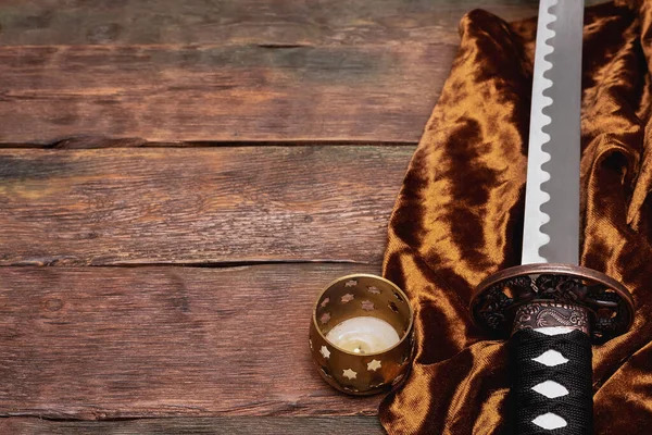 Samuray kılıcı katanası kahverengi masa arkasında bir kumaş üzerinde fotokopi alanı konseptiyle.