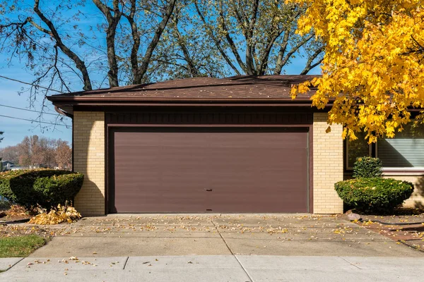 古い茶色のドアとレンガの車のガレージ 秋の多色樹 — ストック写真