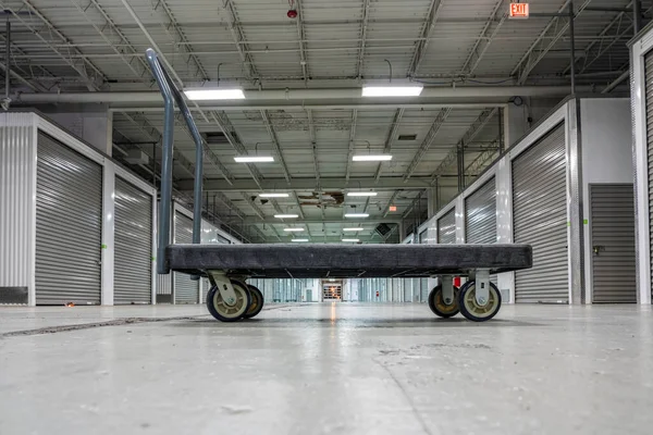 Storage facility corridor with empty platform truck ready to carry boxes or heavy equipment