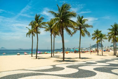 Sunny day on famous Copacabana Beach with palm trees and blue sky in Rio de Janeiro, Brazil