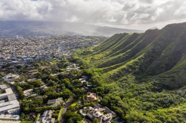 Hawaii 'deki sarp yeşil volkanik dağın gıdalarının bulunduğu Honolulu banliyölerinin havadan görünüşü