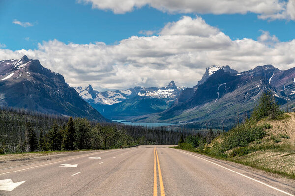 Empty asphalt road leading to Glacier National Park in Montana