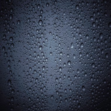 Koyu renk cam üstünde su damlaları