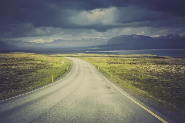 Изогнутая асфальтовая дорога в высоких горах Исландии — стоковое фото