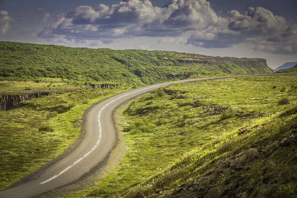 Καμπυλωτό σχήμα άσφαλτο δρόμο στα ψηλά βουνά της Ισλανδίας — Φωτογραφία Αρχείου