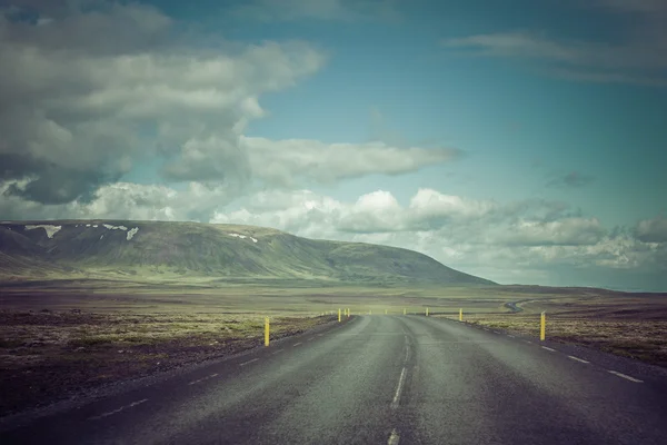 Изогнутая асфальтовая дорога в высоких горах Исландии — стоковое фото