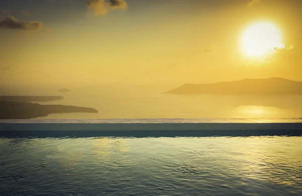 Piscina infinita en la azotea al atardecer en la isla de Santorini, Grecia — Foto de Stock