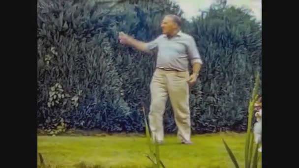 Regno Unito 1968, Man plays with dog in the garden — Video Stock