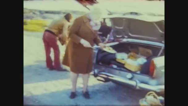 Manchester 1966, Oude dame vult de kofferbak van de auto — Stockvideo