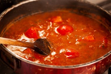 Sıcak saksı kaynarken bir kepçeyle karıştırılır.