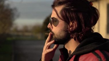 Adam sigara içiyor.