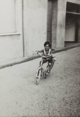 VILLANOVA DEL GHEBBO, ITALY MARCH 1964: 60 'larda bisiklete binen çocuk