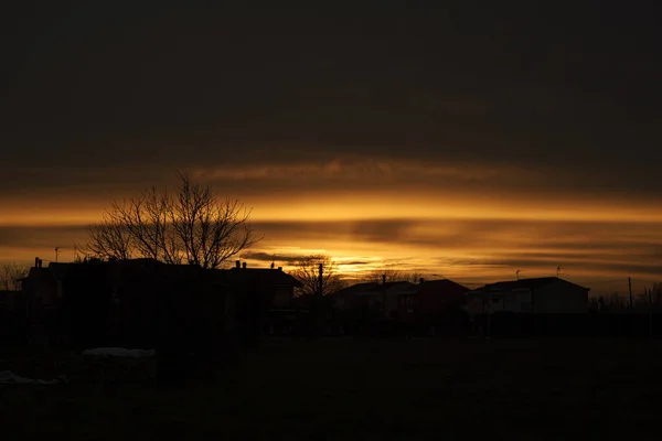 冬の間の村の赤い夕日のシルエット — ストック写真