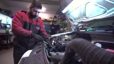 Tamirci araba tamir ediyor.