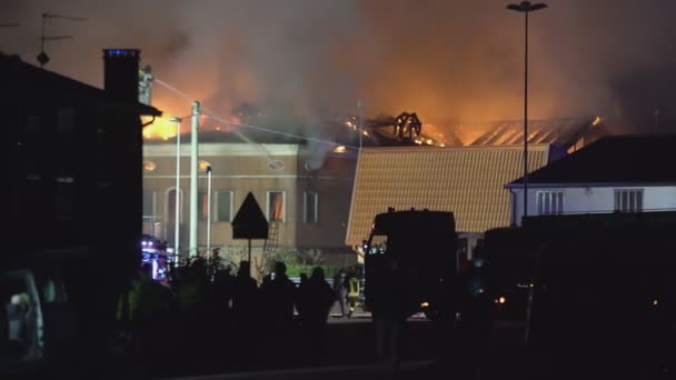 Будинок горить вночі з пожежниками — стокове відео