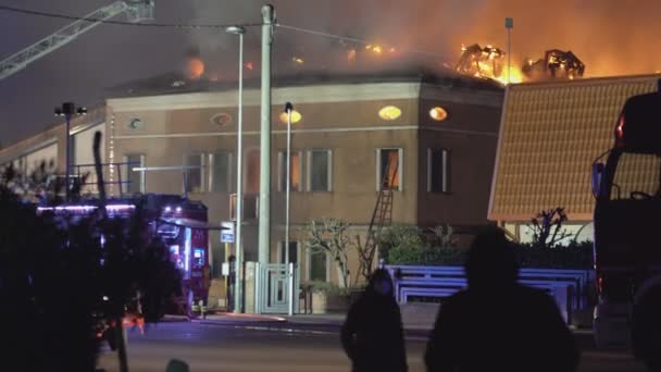 Hus brinner på natten med brandmän — Stockvideo