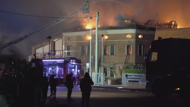 Casa ardiendo por la noche con los bomberos 2 — Vídeo de stock