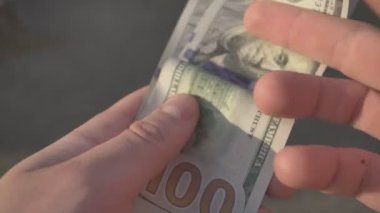 Amerikan Doları 'nın faturalarını sayan ya da nakit ödeme yapan eller. Yatırım, başarı, finansal beklentiler veya kariyer ilerlemesi kavramı.